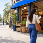 Customer walking into an African grocery store while checking a map on her phone
